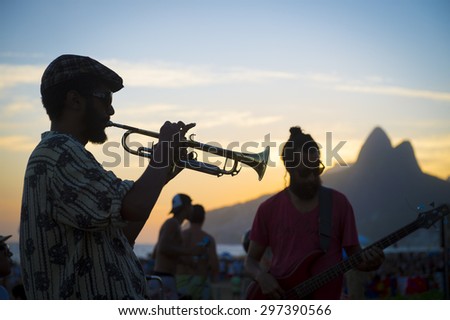 RIO DE JANEIRO, BRAZIL - FEBRUARY 21, 2015: Silhouette of a musician playing his horn to an audience at the popular Arpoador sunset spot near Ipanema Beach.