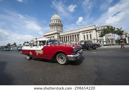 HAVANA, CUBA - CIRCA JUNE, 2011: Classic American Cuban vintage taxi car passes in front of the Capitolio building in Central Havana.
