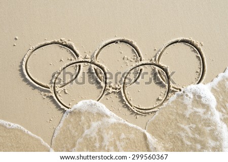 RIO DE JANEIRO, BRAZIL - MARCH 20, 2015: Illustrative editorial of wave approaching Olympic rings drawn in the sand on Ipanema Beach in anticipation of the city hosting the 2016 Summer Games.