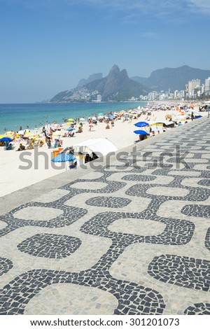 Classic view of Ipanema Beach Rio de Janeiro boardwalk with Two Brothers Mountain under bright blue sky