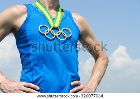 RIO DE JANEIRO, BRAZIL - FEBRUARY 4, 2015: Olympic rings gold medal hangs from Brazil colors ribbon on the chest of an athlete standing against blue sky. [Illustrative editorial]