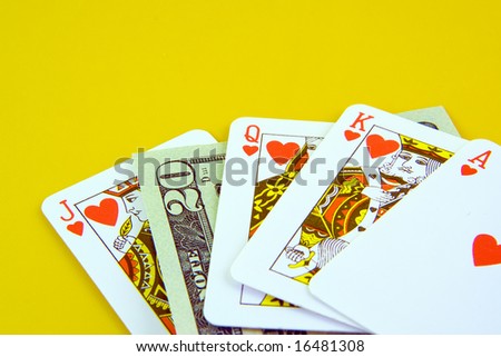 Deck of playing cards and twenty dollars isolated on yellow background