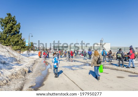 Montreal, Canada - February 23, 2014: People Wandering Around the Old Port on a Clear Winter Day. The Old Port, used as early as 1611 stretches for over two kilometres along the St. Lawrence river.