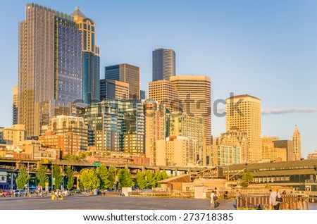 Seattle, WA. USA - July 7, 2014: Seattle Skyline at Sunset from the Waterfront. Visitors of the Waterfront can enjoy fresh seafood, shops, scenic ferry rides, or a visit to the Seattle Aquarium.