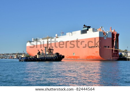 A Tug Boat Approaching a Huge Cargo Ship