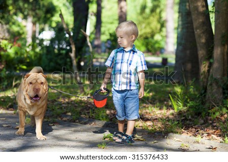 Little boy walks the dog