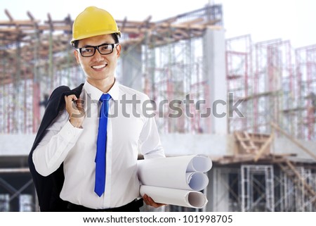 Happy smiling engineer holding a blueprint shot at workplace outdoor