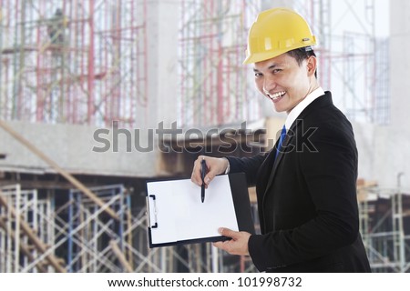 Smiling supervisor showing blank clipboard shot at workplace outdoor
