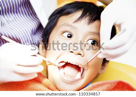 Close-up of little boy opening his mouth wide during inspection of oral cavity by dentist