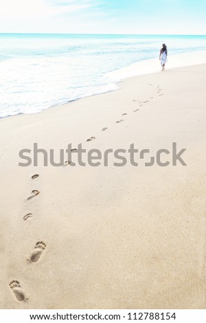 Shot of footprints with woman walks on the tropical beach. Shot in maldives