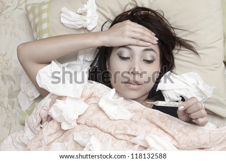 Woman is having high fever and resting on her bed