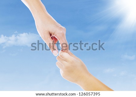 A hand reaching out to the sky. Picture of a mother hand holding her son\'s hand