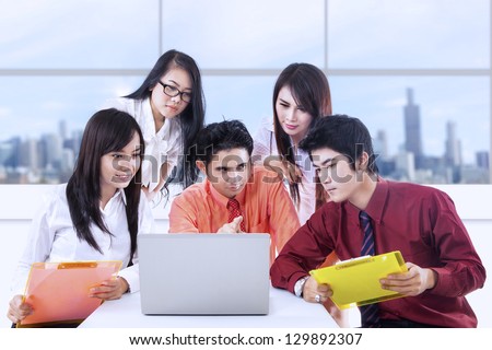 Asian business discussion in the office using laptop