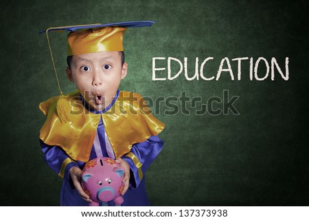 Boy holding piggybank shock on education fees