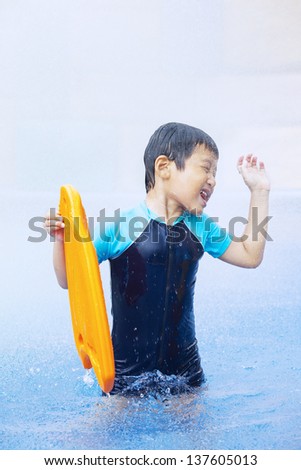 Boy having fun in the swimming pool inside a water park