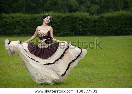 Beautiful woman dancing with formal dress at the park