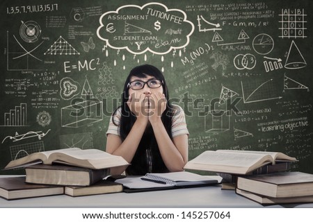 Beautiful female student worry about the exam in classroom