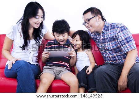 Excited family playing game together using e-tablet on white background