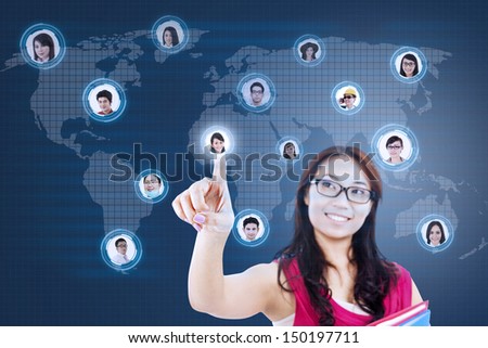 Asian student clicking on the social networking map with digital world map