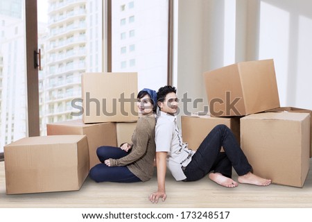 Young couple resting while moving into a new home.
