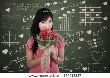 Woman with flowers standing in front of the formula of love