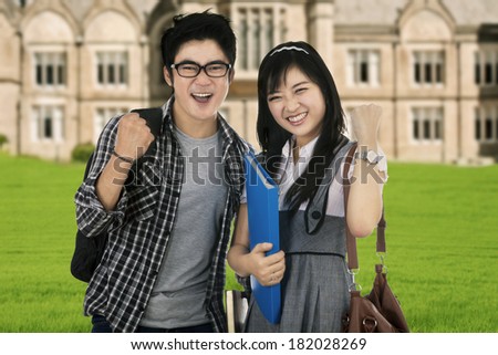 Happy trendy college students with bags and books, expressing success