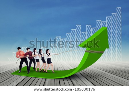 Portrait of business team pulling up bar using rope. growth chart concept
