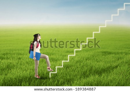 College student stepping up on stairs to gain her success
