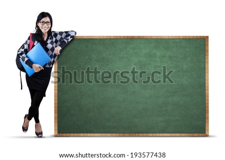 Female college student standing next to copy space. isolated on white background