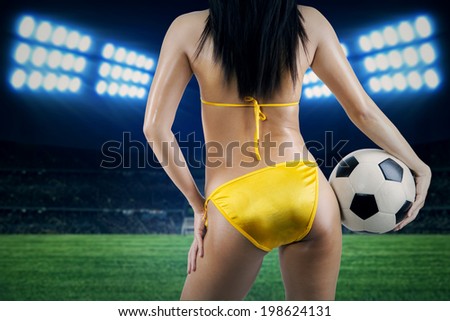 Woman\'s Sexy Backside Holding a Soccer Ball.