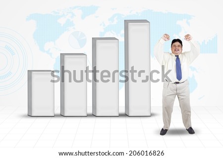 Fat businessman celebrate his success while standing near to financial graph