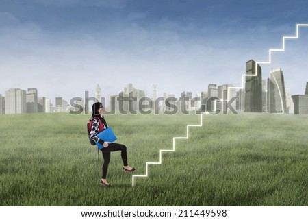 College student stepping up on stairs to gain her success