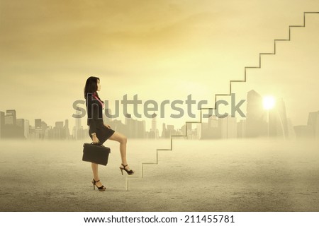 Young businesswoman walking up on stairs for success