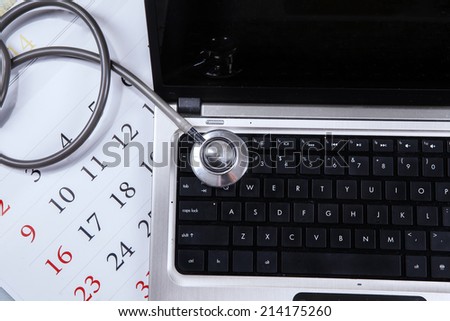 Laptop computer, stethoscope, and calendar symbolizing international health day