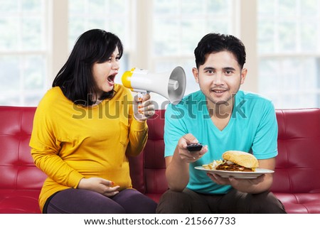 Portrait of angry pregnant woman at her husband in the home