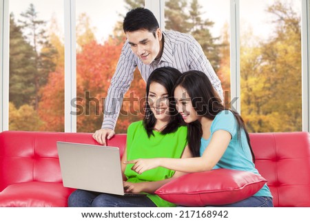 Group of young student using laptop computer at home with autumn tree background