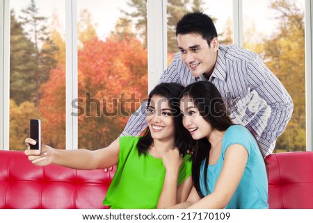 Group of young asian people take self portrait at home with autumn tree background