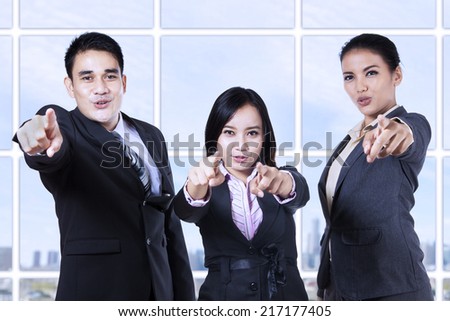 Group of asian business people pointing at camera