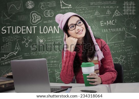 Attractive girl studying in the classroom and dreaming about student loan while wearing winter wear