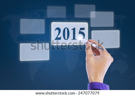 Closeup of hand using stylus to press a virtual button with number 2015 on the high tech screen