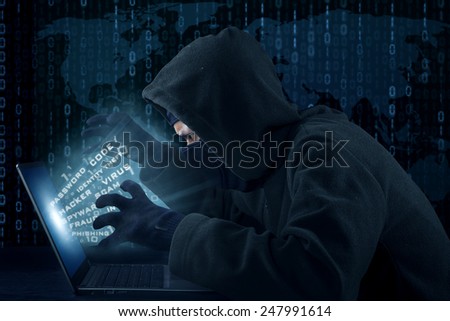 Portrait of male hacker wearing black mask and stealing user identity
