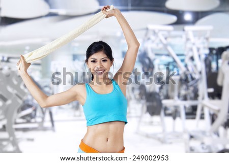 Attractive fitness woman with white towel in fitness center