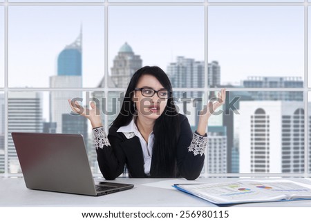Young asian female worker doing her job in the office and looks confused