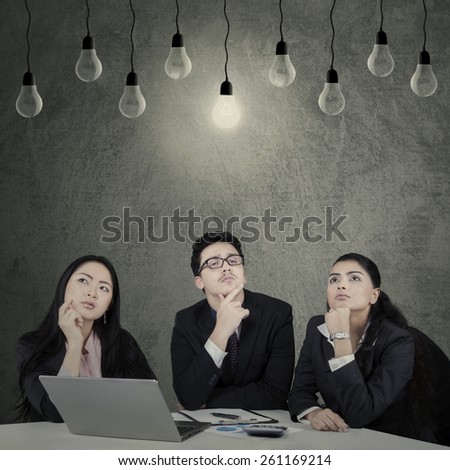 Portrait of three multi ethnic businesspeople with thinking expression to find the solution