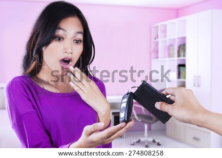 Shocked girl receiving a new car key at home, symbolizing new owner