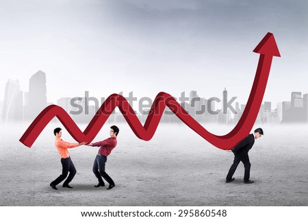 Three young workers carrying financial chart together outdoors, symbolizing a cooperation to increase business