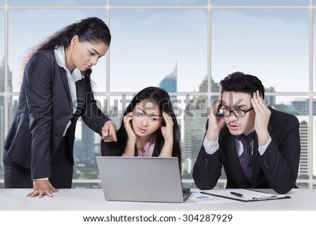 Portrait of young manager pointing at the laptop and show the mistake of her team