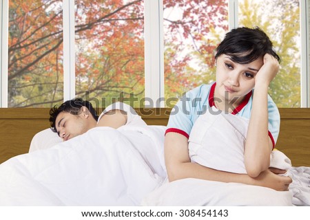 Portrait of young woman can not sleep on bedroom with her husband