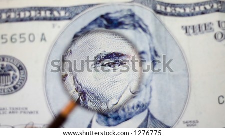Looking at five dollar bill through magnifying glasses
