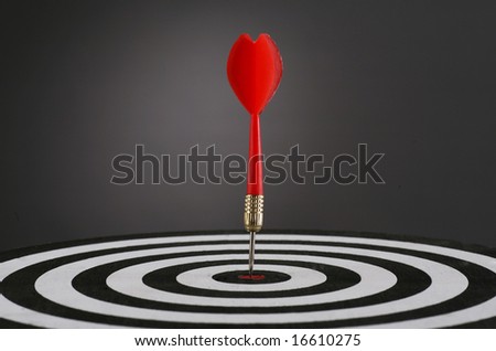 Portrait shot of a Red dart on bull's eye of a dart board